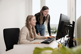 An intern in civil engineering receives support from a working student.