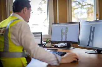 Ein Bauingenieur der Zentralen Technik (STRABAG) blickt auf seine Bildschirme mit Planungsmodellen der Satu-Mare-Brücke.