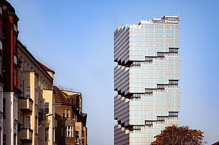 Im Vordergrund Wohnhäuser, im Hintergrund der EDGE East Side Tower in Berlin.