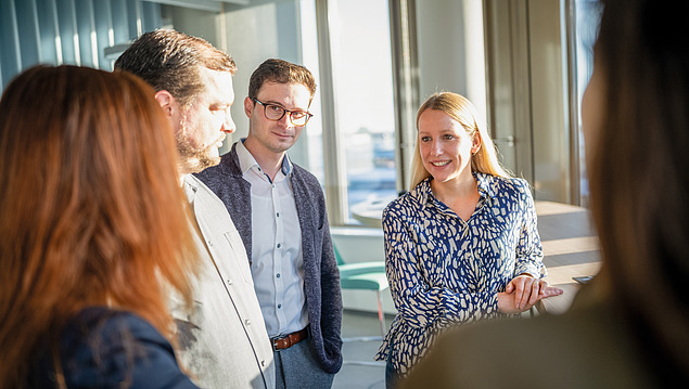 The picture shows five employees from Zentrale Technik exchanging ideas as part of service phases 1-9.