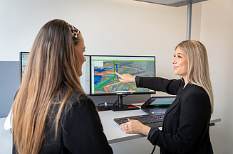 Eine Studentin im dualen Studiengang Bauingenieurwesen zeigt auf ein digitales Planungsmodell auf ihrem Monitor.