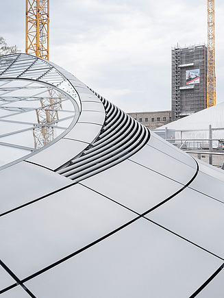 The photo shows the light eye of the new Stuttgart 21 station including construction cranes in the background