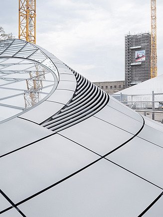 The photo shows the light eye of the new Stuttgart 21 station including construction cranes in the background
