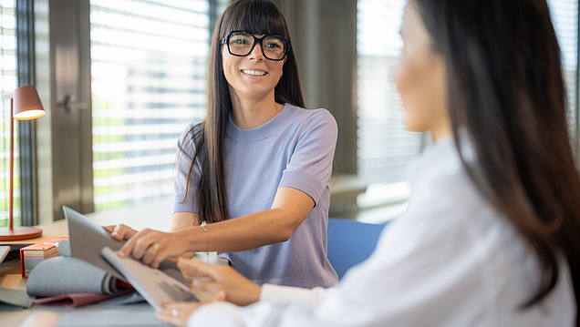The picture shows two employees from Zentrale Technik talking to each other.