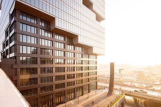 Das Bild zeigt das Erdgeschoss des EDGE East Side Tower am Bahnhof Warschauer Straße in Berlin während des Sonnenaufgangs.