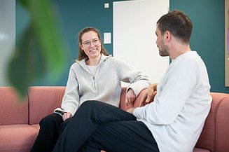 Zwei Mitarbeitende unterhalten sich in der Lounge der Zentralen Technik.