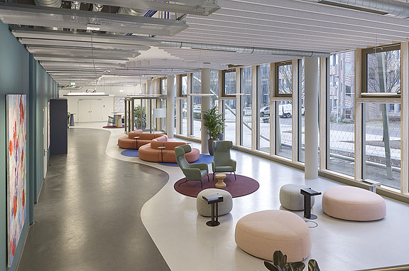 Bright, modern interior of the Z2.0 building in Stuttgart with large window fronts, comfortable seating and open structures. The design promotes daylight, comfort and a healthy indoor climate for a greater sense of well-being.