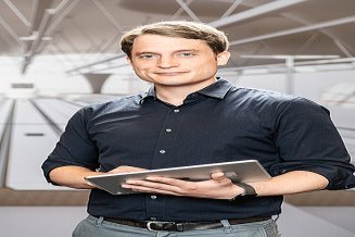 Ambrosius, BIM-Manager bei der Zentralen Technik, steht vor einer Visualisierung des neuen Stuttgarter Hauptbahnhofs.