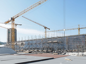 Das Bild zeigt viele Kräne und den von einem Baugerüst umgebenen Bonatzbau.