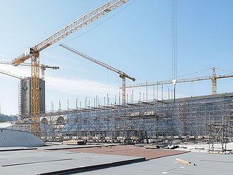 Das Bild zeigt viele Kräne und den von einem Baugerüst umgebenen Bonatzbau.
