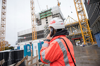 Ein ZÜBLIN-Bauleiter führt ein wichtiges Telefonat auf der Baustelle.