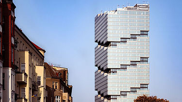 Im Vordergrund Wohnhäuser, im Hintergrund der EDGE East Side Tower in Berlin.