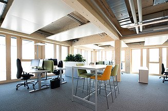 The office offers both desks and meeting tables for working together.