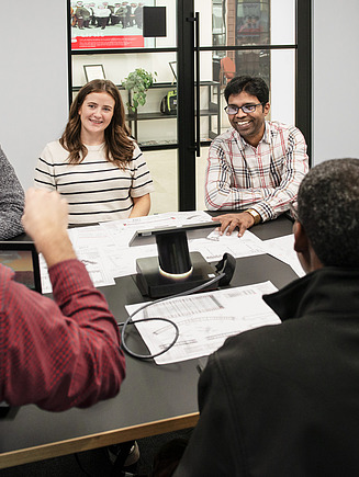 Eine Auszubildende wohnt einer Besprechung bei.
