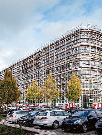 Das Bürogebaude Z2.0 während der Sanierung von außen - es ist von einem Gerüst umgeben.