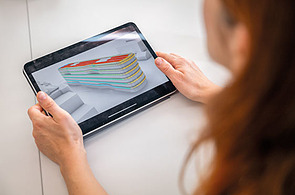 The picture shows a woman examining the digital model of the Z2 building. Sustainability considerations can be seen.