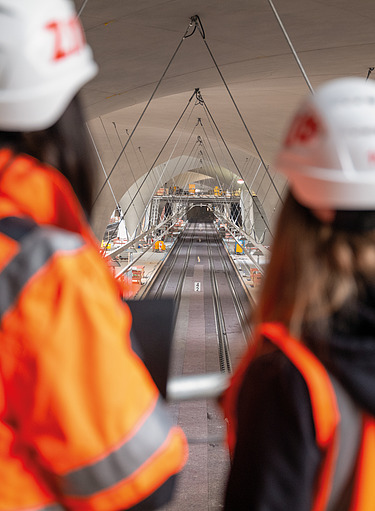 The photo shows the Stuttgart 21 construction site with track systems, goblet supports and open hall construction.