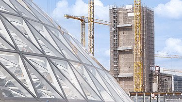 Im Vordergrund befindet sich einer der Haupteingänge von Stuttgart 21, im Hintergrund der Turm des Bonatzbaus am Arnulf-Klett-Platz.